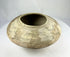 Side view of Indus Valley pottery bowl with symbolic fish motifs and natural clay surface.