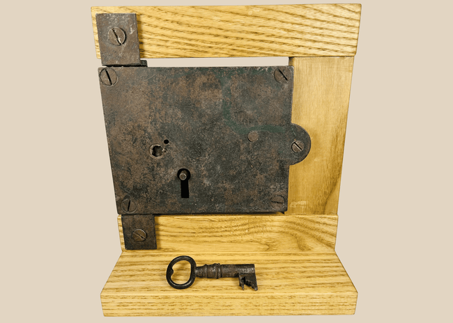 Antique 19th century iron rim lock with original skeleton key on display