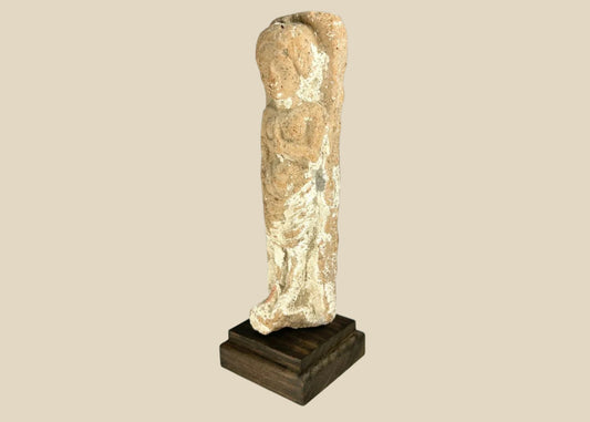 Iron Age terracotta fertility goddess figurine from the Levant, circa 600–300 BCE, stylized female form with one arm raised to the breast; faint red and white pigment traces visible on the surface, symbolizing abundance and protection.