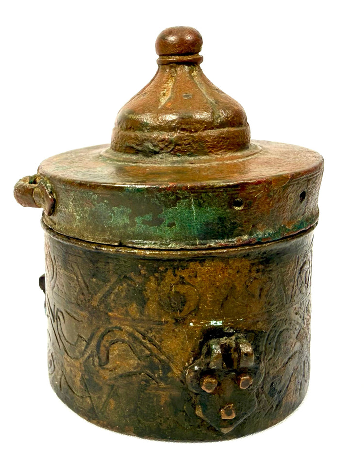 Khorassan bronze inkwell featuring surviving applied metal fittings, decorative engravings, and an irregular archaeological surface texture.