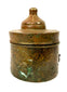 Medieval Islamic bronze inkwell displaying engraved curvilinear ornamentation, localized oxidation, and centuries-old surface wear.