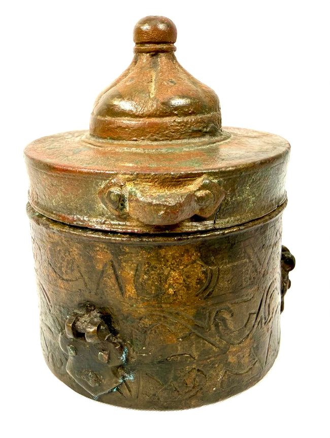 Islamic Golden Age bronze inkwell displaying intricate engraved scrolling, geometric, and circular motifs across its cylindrical body.
