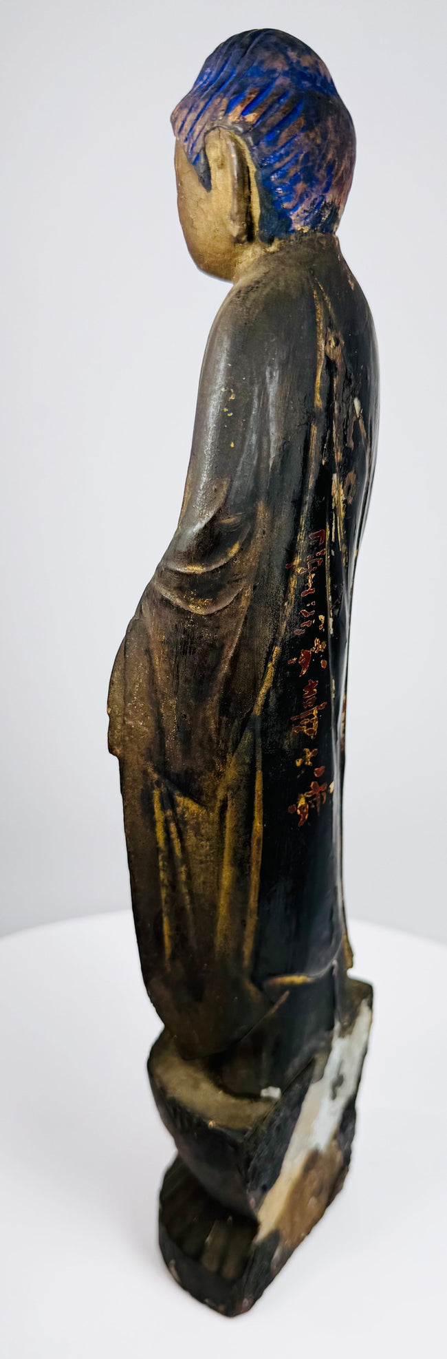 Side view of the carved wood Amida Buddha showing its flowing monastic robes