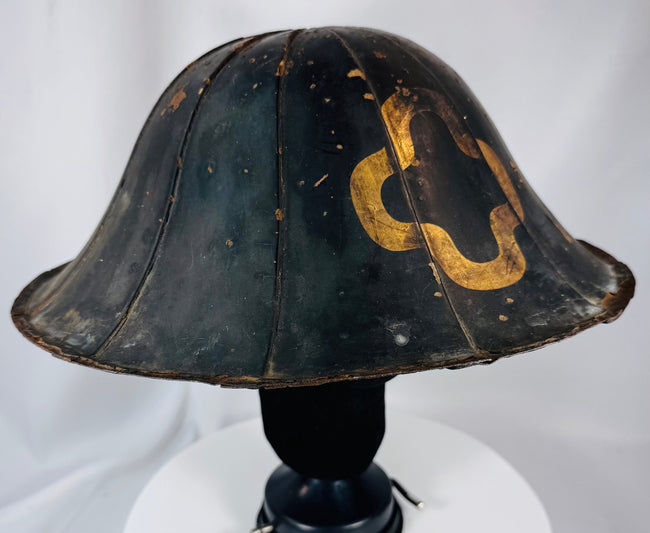 Historic Japanese samurai helmet with weathered lacquer finish and visible age-related wear