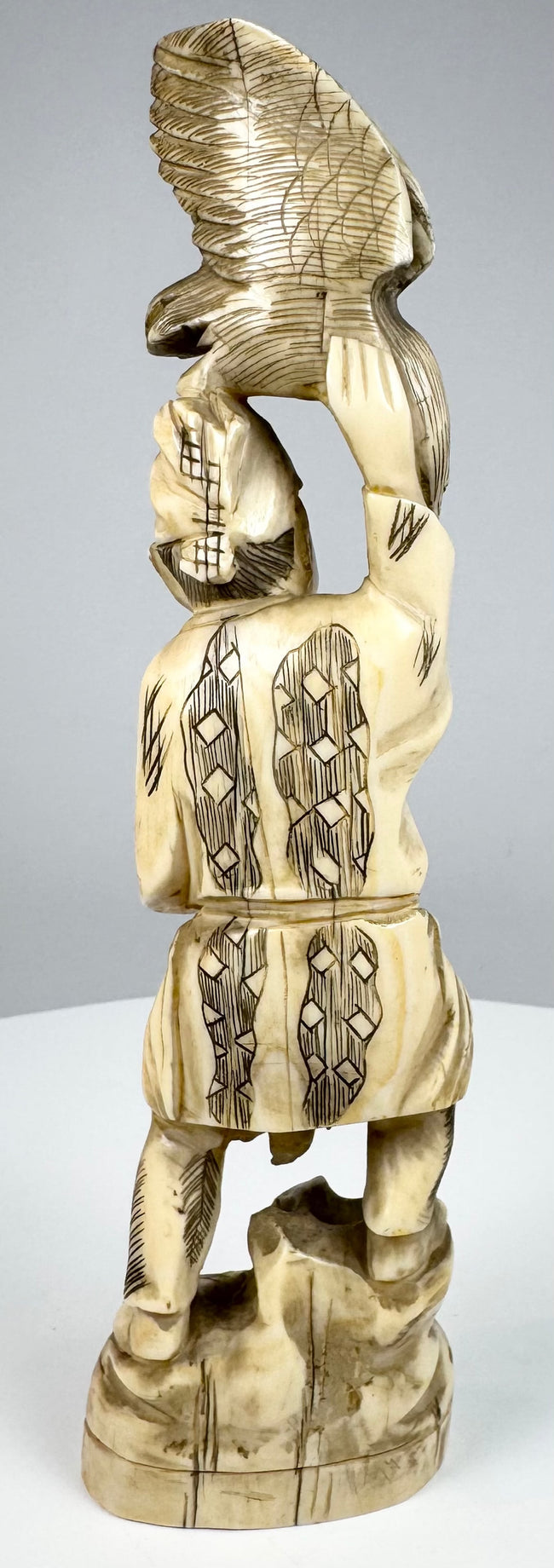 Japanese falconer carving with geometric clothing patterns and seigaiha head covering