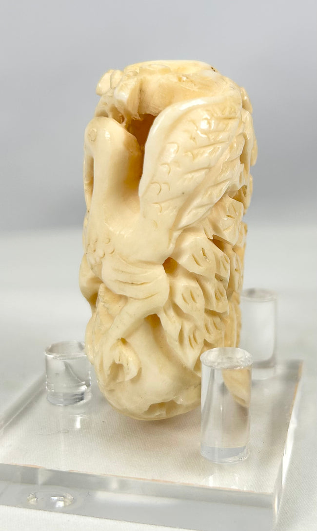 Intricately pierced Japanese bone sculpture showing birds among flowing leaves, circa 1890–1930