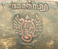 Back view of stamp or carving on a late 19th-century Javanese carved wooden Cakil mask showing interior surface and hanging cord on a black display stand.