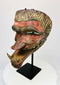 Late 19th-century Javanese carved wooden Cakil mask with polychrome paint displayed on a black stand.