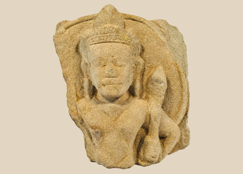 Carved stone fragment of Padmapani (Avalokitesvara) from 12th-century Khmer Empire, Cambodia, showing serene facial features and flowing contours, mounted for display.