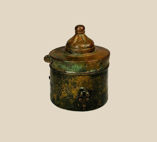 Islamic Khorassan bronze inkwell, 10th–12th century CE, with domed lid, cylindrical body, and finely engraved floral and geometric motifs, showing rich green and brown patina.