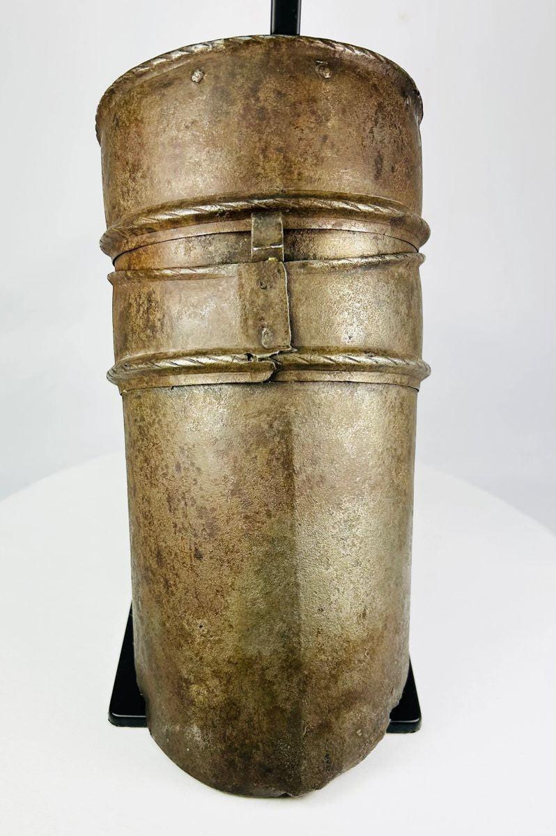 Renaissance knight’s upper arm defense, 16th-century cannon-style armor plate with riveted bands, aged surface, and mounted for display.