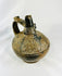Angled view of Sicán blackware vessel displaying rounded body, burnished finish, and high spout from Lambayeque culture.