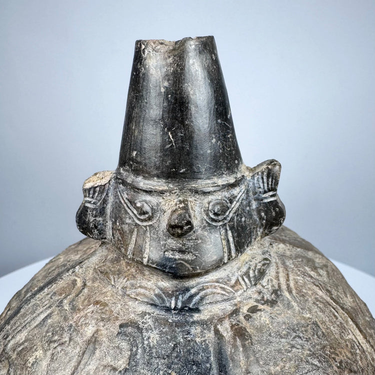 Ancient Peruvian blackware bottle from the Sicán culture with preserved burnishing and traditional vessel form.