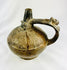 Ancient Peruvian Sicán blackware vessel with sculpted side handle and polished body, Lambayeque Valley region.