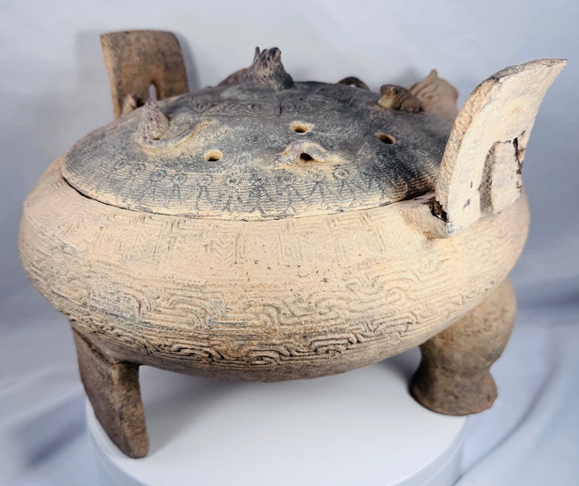 Ancient Chinese terracotta vessel displaying incised decorative bands, mineral deposits, and evidence of burial.