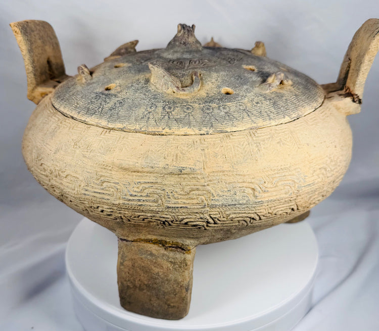 Rear view of a large terracotta ritual vessel from ancient China showcasing its upright handles and sculptural form.