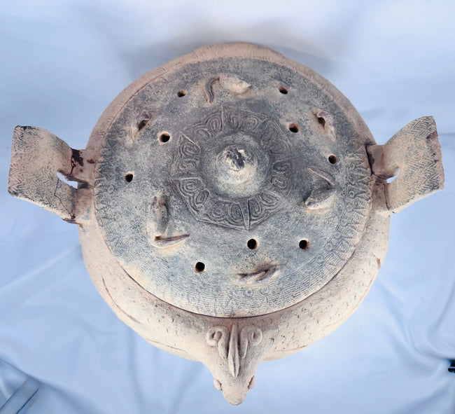 Side profile of an ancient Chinese terracotta ritual vessel highlighting its tripod feet and zoomorphic body.