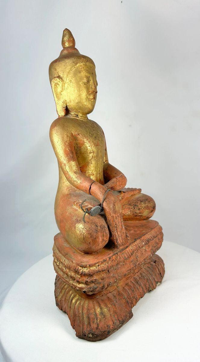 Side profile of a 19th-century Burmese wooden monk statue showing carved robe details