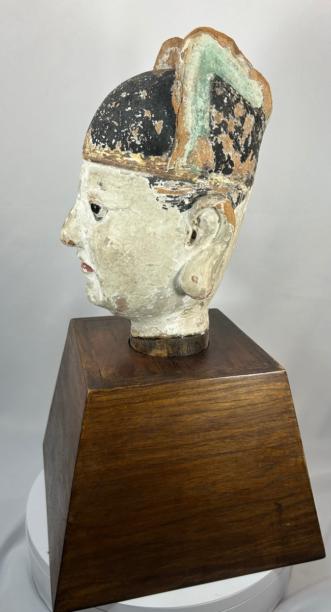 Chinese temple bust of a scholar-official with black ceremonial hat and red lips.