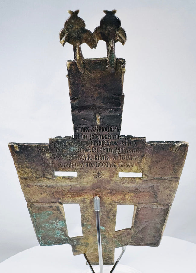 Russian bronze devotional cross depicting Christ on the cross surrounded by saints and sacred inscriptions.