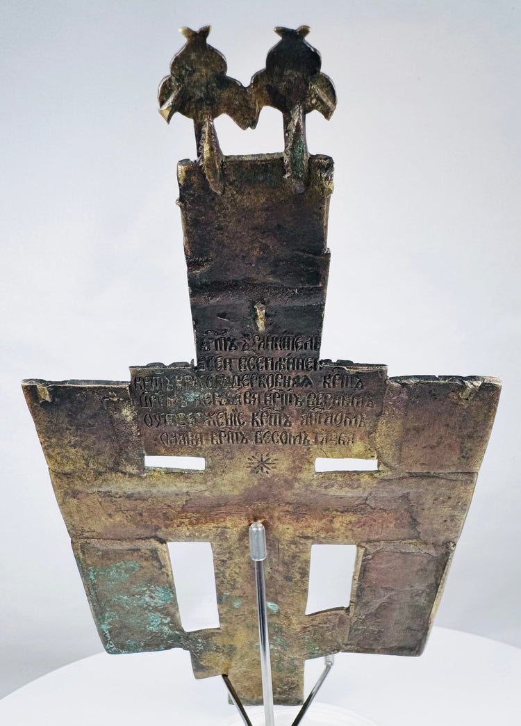 Russian bronze devotional cross depicting Christ on the cross surrounded by saints and sacred inscriptions.