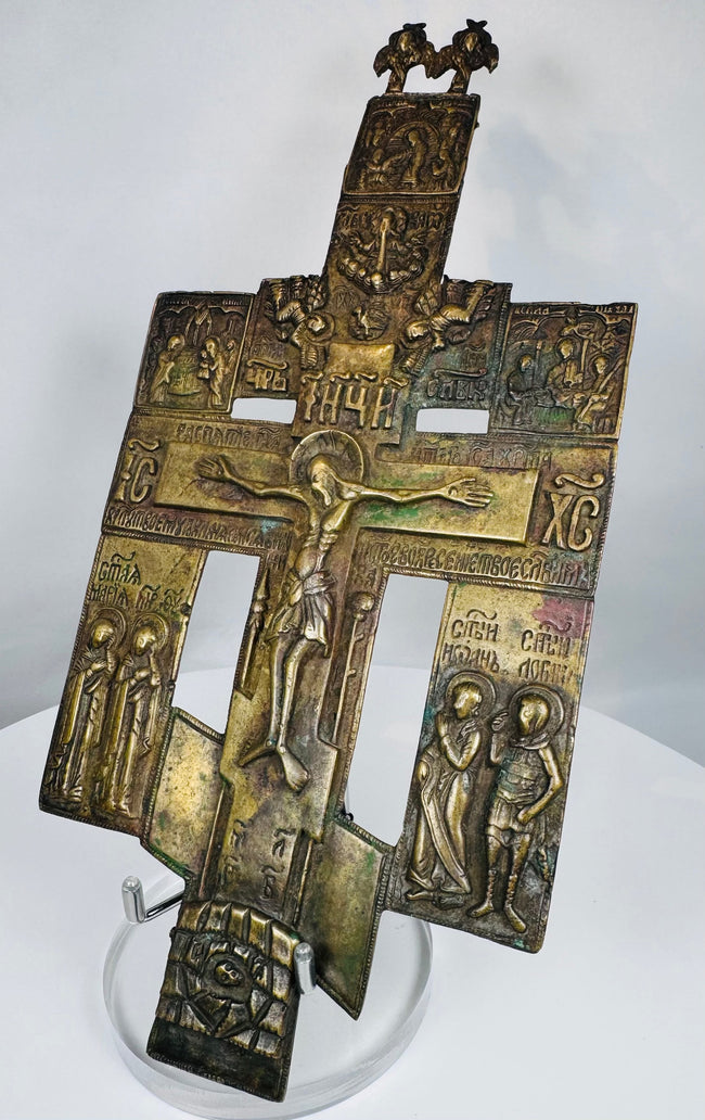 Historic Russian devotional cross featuring a central crucifixion panel and ornate religious imagery.
