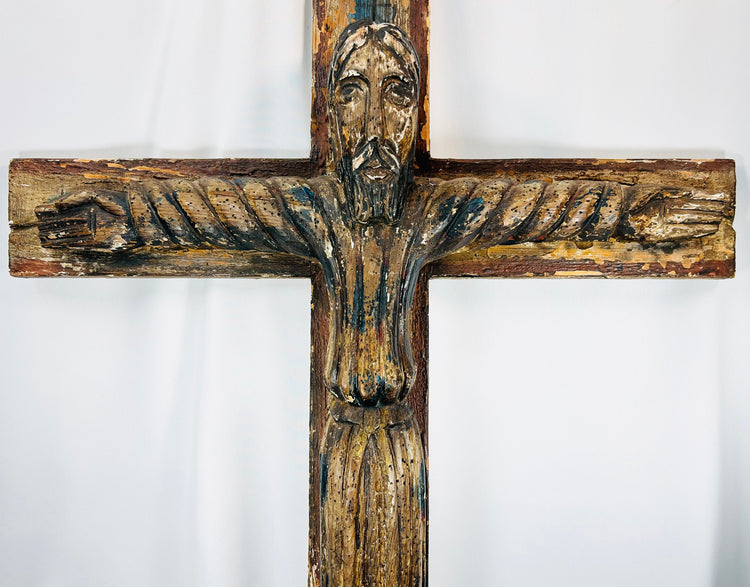 Antique devotional crucifix from Spanish Colonial tradition with elongated Christ figure.