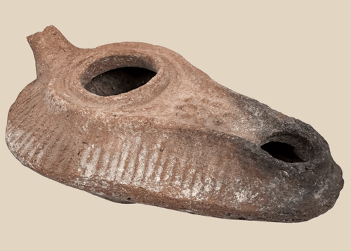 Late Antique terracotta oil lamp with elongated slipper-shaped body and soot-stained nozzle