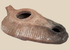 Late Antique terracotta oil lamp with elongated slipper-shaped body and soot-stained nozzle