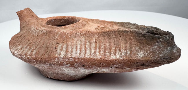 Ancient Levantine terracotta lamp with central filling hole and extended wick opening