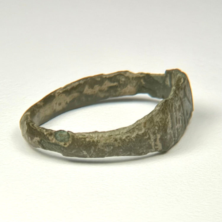 Rear view of ancient Roman bronze finger ring with irregular archaeological surface and surviving patina