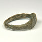 Rear view of ancient Roman bronze finger ring with irregular archaeological surface and surviving patina