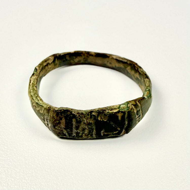Ancient Eastern Mediterranean bronze ring with flattened engraved front and extensive age-related wear