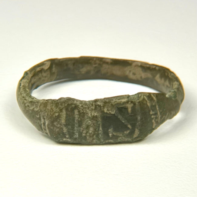 Ancient Roman bronze ring showing broad flattened bezel with incised vertical and diagonal decoration