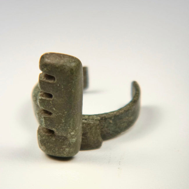 Late Imperial Roman bronze ring key with projecting rectangular bit, historic repair, surface pitting, and mineral encrustation