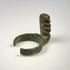 Late Roman bronze key ring with four projecting teeth, heavy patination, and visible older repair or remounting