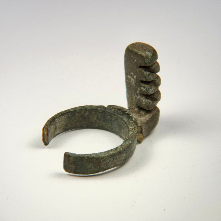Late Roman bronze key ring with four projecting teeth, heavy patination, and visible older repair or remounting