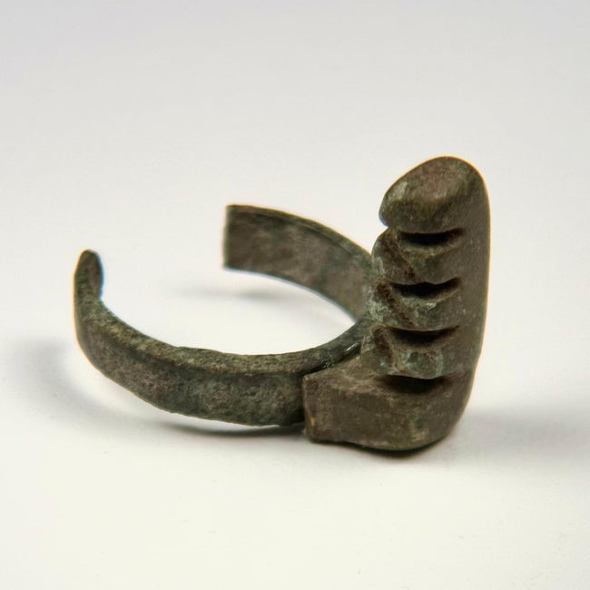 Ancient Roman copper-alloy ring key showing a substantial projecting lock mechanism and open-ended band