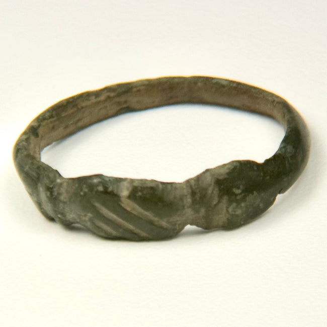 Late Antique bronze finger ring with solid cast hoop, expanding shoulders, and geometric incisions