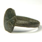 Close-up of Byzantine bronze signet ring with weathered incised cruciform bezel and naturally aged surface