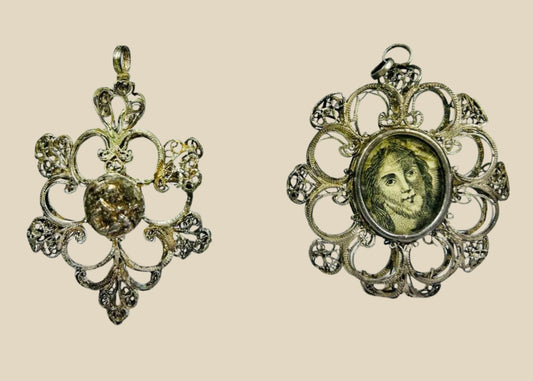 Antique 19th-century Catholic devotional pendant with ornate silver filigree frame and engraved portrait of Christ under glass, likely Italian or Spanish origin.