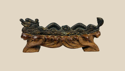 Chinese bronze incense holder depicting a coiled dragon with archaic motifs, mounted on a hand-carved hardwood base shaped like clouds or flames, showing patina and minor surface oxidation, circa 1900–1930, Late Qing to Early Republic Era.