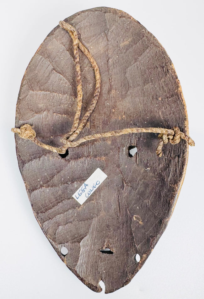 Hand-carved Lega Bwami society passport mask with original suspension holes and aged patina.