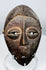 Central African Lega mask featuring simplified symbolic facial features and original fiber cord remnants.