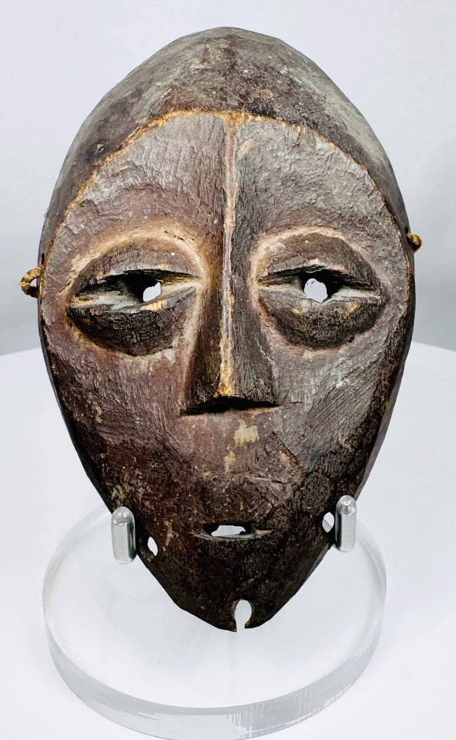 Wooden Lega devotional mask from the Democratic Republic of the Congo with rich dark patina.
