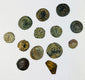 Roman coin reverse with military emblem and heavily patinated bronze surface