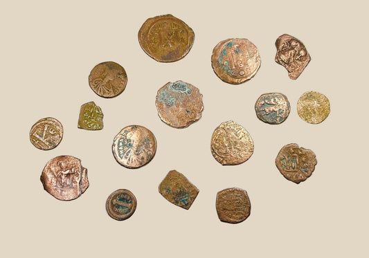 Collection of 16 ancient Roman and Byzantine bronze coins, circa 2nd–7th century AD, featuring worn imperial busts, Christian symbols, and reverse motifs; varied sizes and patinas with green oxidation and surface wear, representing authentic currency circulation across late antiquity and the early Byzantine Empire.