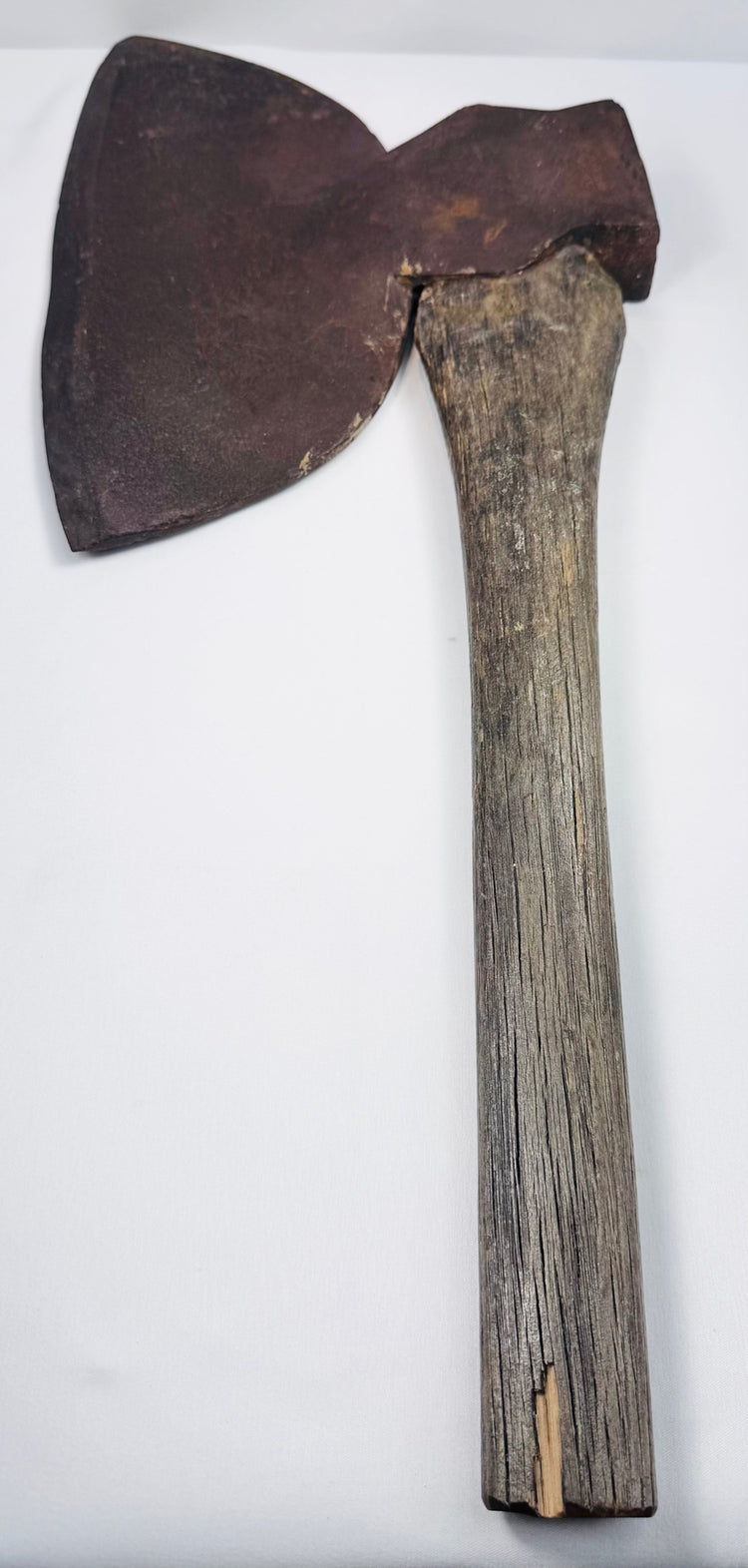 Side profile of a 19th-century woodman’s axe showing its broad cutting blade and flat reverse striking surface.