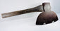 Angled close-up of the M.H. Jones & Co. axe head highlighting the curved cutting edge and heavily patinated steel surface.