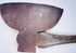 Close-up of an antique American broad axe head showing its wide curved cutting blade and aged forged steel surface.